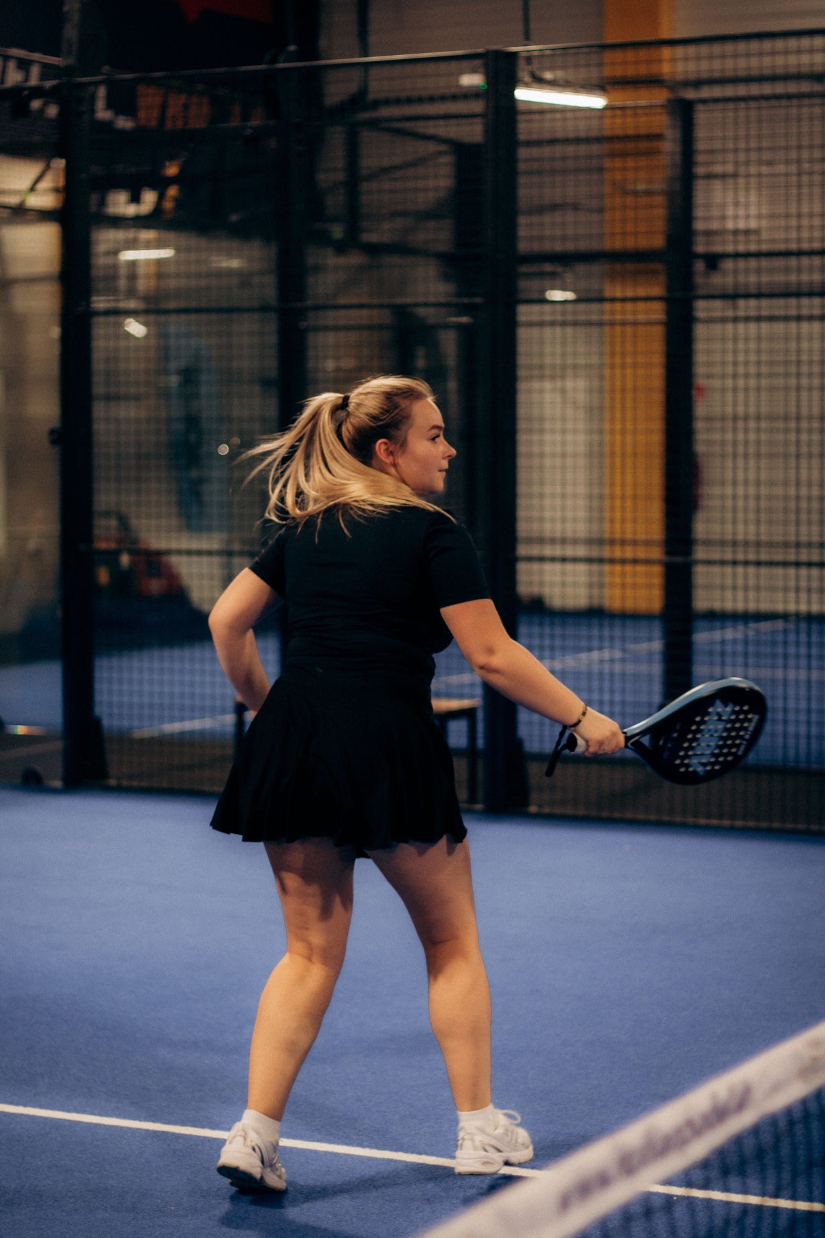 Giocatrice di padel in movimento sul campo